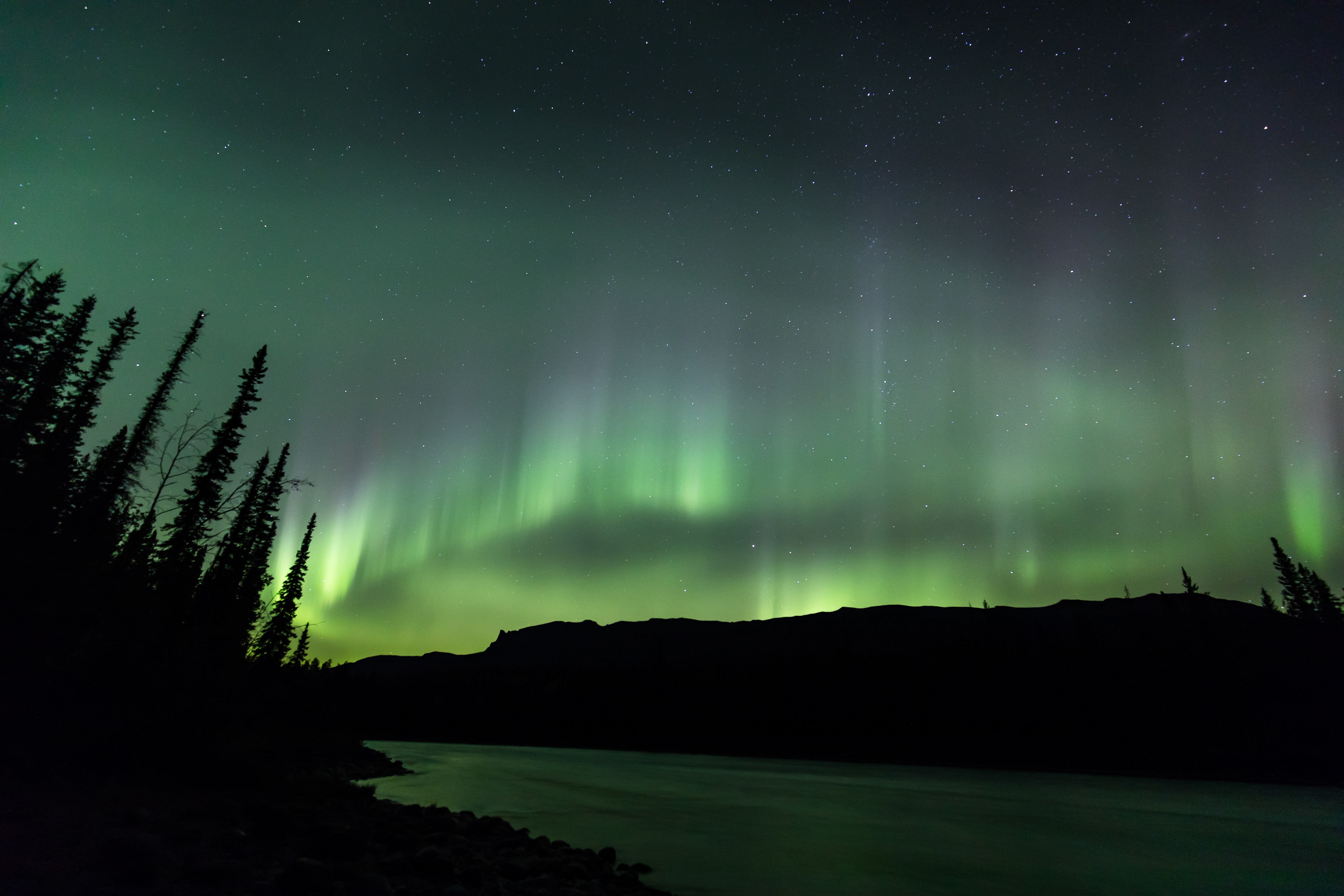 Aurora boreal sobre un río en el Parque Nacional Jasper, Canadá